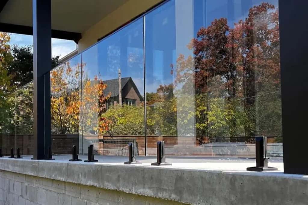 Stainless steel spigot glass railing with aluminum top rail on a High Park porch, Toronto